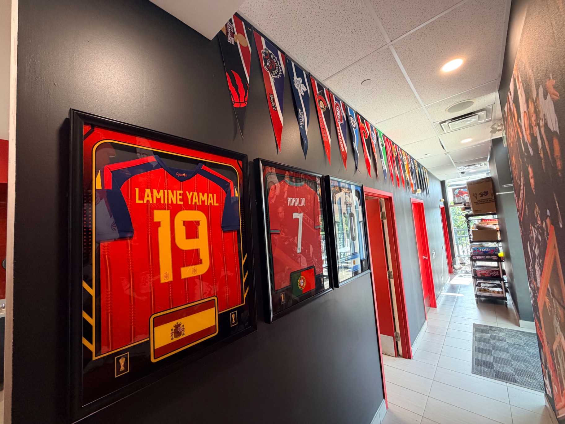 Hall of Flame hallway lined with framed football jerseys and team pennants